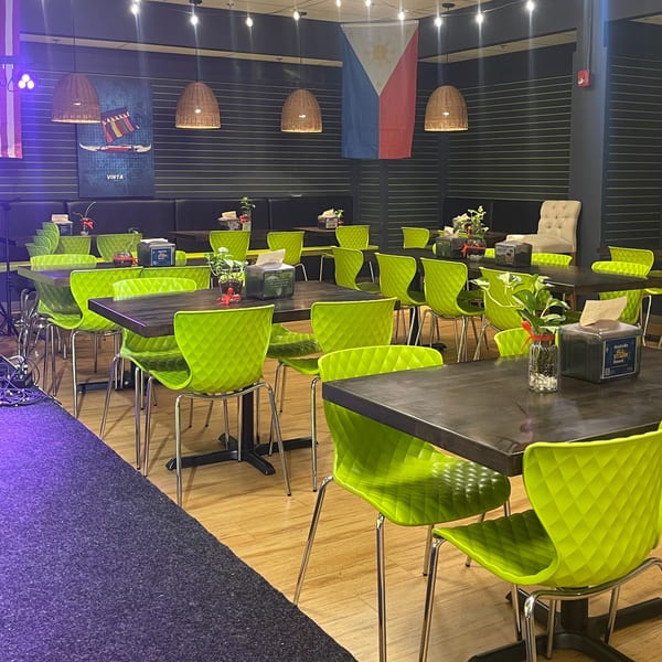 Maemax Market's dining area with neon green chairs, dark tables, and a Philippine flag on the wall.