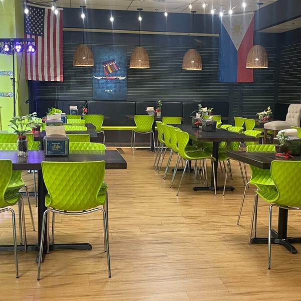 Maemax Market's dining area with bright green chairs, dark tables, and Filipino and American flags.